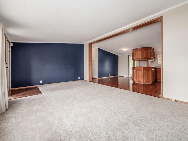 unfurnished living room with wood-type flooring, a textured ceiling, and crown molding