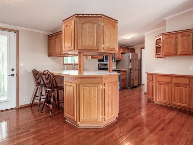 kitchen with dark wood-type flooring, sink, crown molding, appliances with stainless steel finishes, and kitchen peninsula