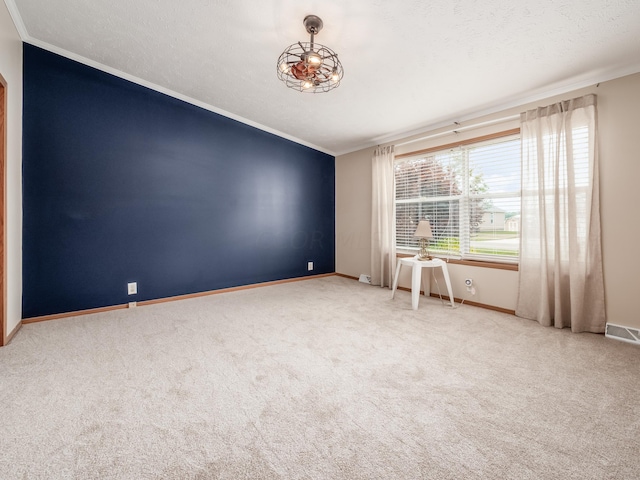 carpeted empty room with a textured ceiling and ornamental molding