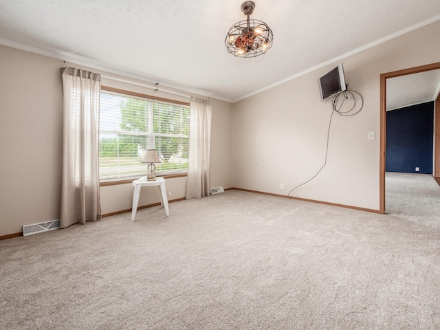 carpeted empty room with a textured ceiling and crown molding