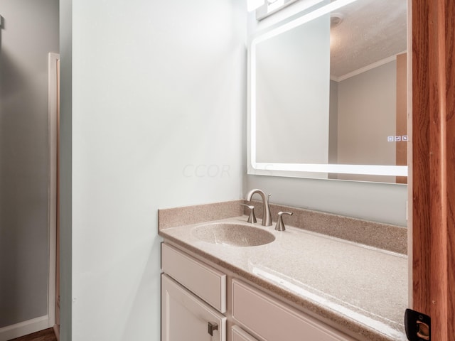 bathroom with vanity, crown molding, and a textured ceiling