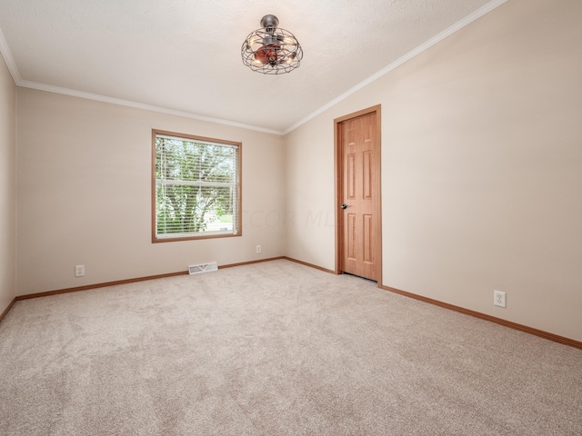 carpeted empty room featuring a textured ceiling, crown molding, and vaulted ceiling