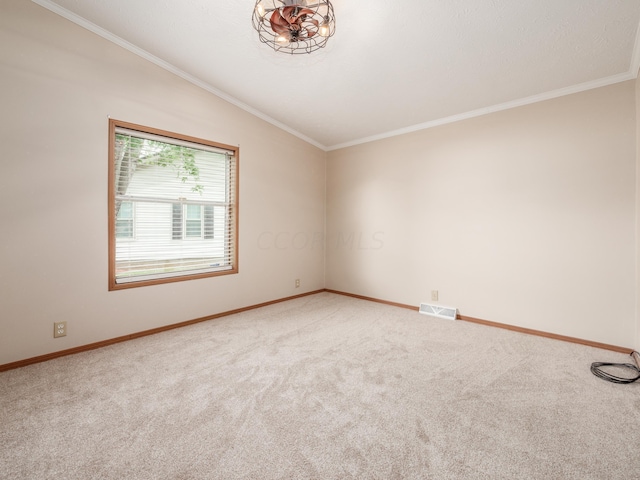 carpeted spare room featuring crown molding and vaulted ceiling