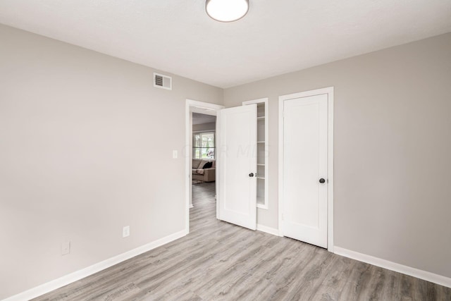 unfurnished bedroom featuring a closet and light hardwood / wood-style flooring