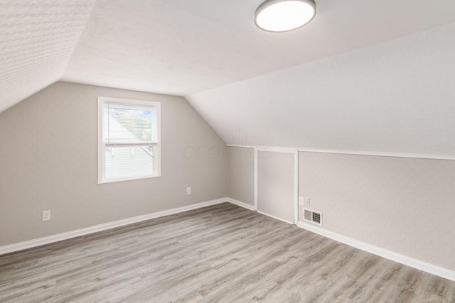 bonus room featuring light hardwood / wood-style flooring and lofted ceiling