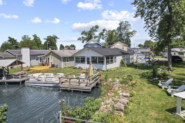 rear view of property featuring a deck with water view, a yard, and a storage shed