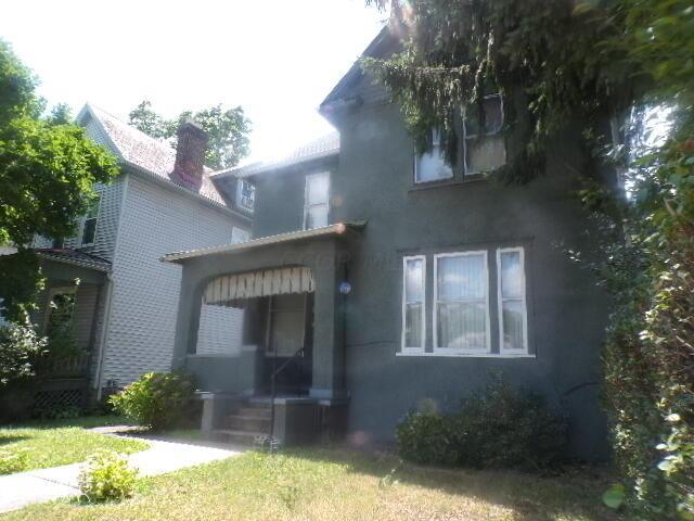 2343 Indianola Ave, Columbus, OH 43202 - rear view of property with stucco siding, a chimney, and a lawn
