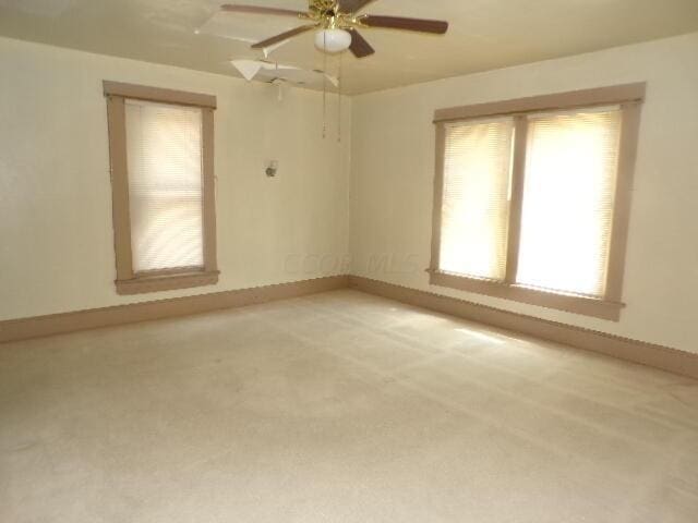 carpeted spare room with ceiling fan