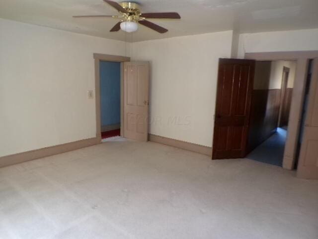 empty room featuring carpet flooring and ceiling fan