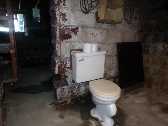 bathroom featuring toilet and concrete flooring