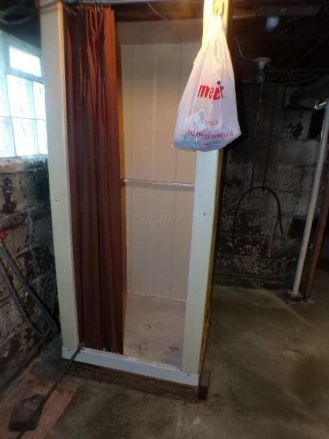 bathroom featuring curtained shower and concrete flooring