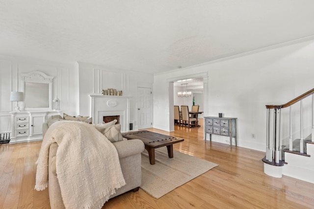 living room featuring light wood-type flooring and ornamental molding