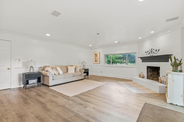 living room with a fireplace, light hardwood / wood-style flooring, and ornamental molding