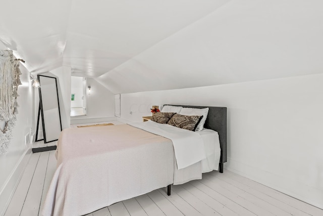 bedroom featuring light hardwood / wood-style flooring and vaulted ceiling