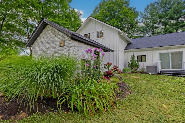 back of property featuring a lawn and central AC unit