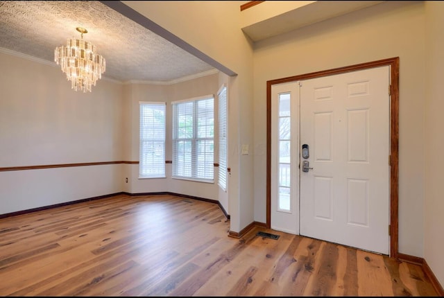7265 Bromfield Dr, Canal Winchester, OH 43110 - entryway featuring wood finished floors, a chandelier, ornamental molding, and a textured ceiling