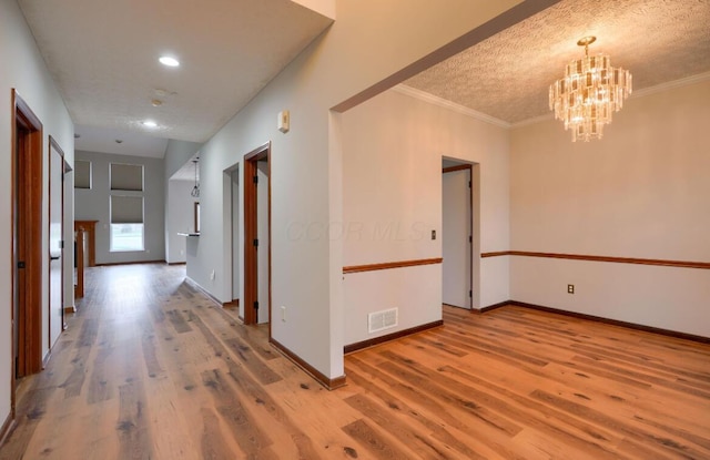 7265 Bromfield Dr, Canal Winchester, OH 43110 - hall with light wood-type flooring, a chandelier, crown molding, a textured ceiling, and recessed lighting