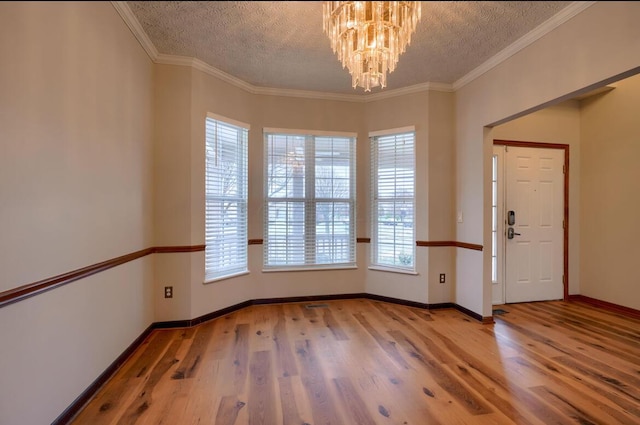 7265 Bromfield Dr, Canal Winchester, OH 43110 - spare room featuring wood finished floors, plenty of natural light, a chandelier, a textured ceiling, and crown molding