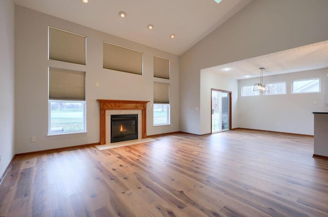 7265 Bromfield Dr, Canal Winchester, OH 43110 - unfurnished living room featuring healthy amount of natural light, a fireplace, wood finished floors, high vaulted ceiling, and recessed lighting
