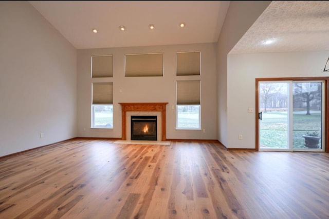 7265 Bromfield Dr, Canal Winchester, OH 43110 - unfurnished living room with plenty of natural light, wood finished floors, lofted ceiling, a fireplace with flush hearth, and recessed lighting