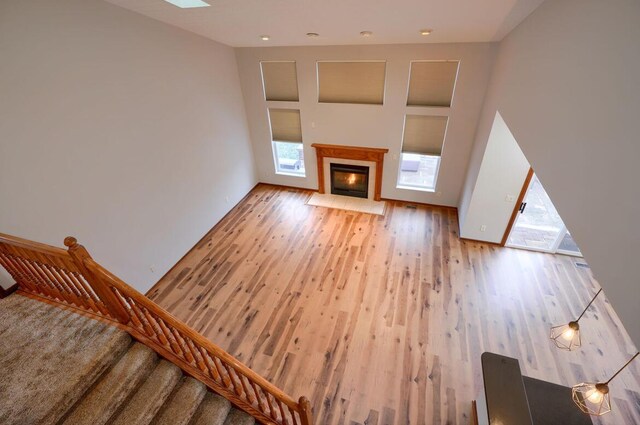 7265 Bromfield Dr, Canal Winchester, OH 43110 - unfurnished living room with wood finished floors, stairway, a fireplace with flush hearth, and a skylight
