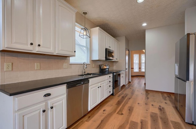 7265 Bromfield Dr, Canal Winchester, OH 43110 - kitchen with stainless steel appliances, dark countertops, white cabinetry, a textured ceiling, and tasteful backsplash