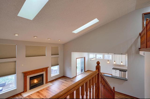 7265 Bromfield Dr, Canal Winchester, OH 43110 - stairway featuring a skylight, wood finished floors, a fireplace with flush hearth, a textured ceiling, and vaulted ceiling