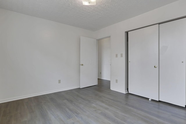 unfurnished bedroom featuring hardwood / wood-style floors, a textured ceiling, and a closet