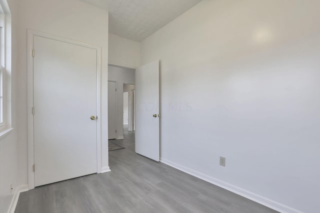 unfurnished bedroom featuring light wood-type flooring and a textured ceiling