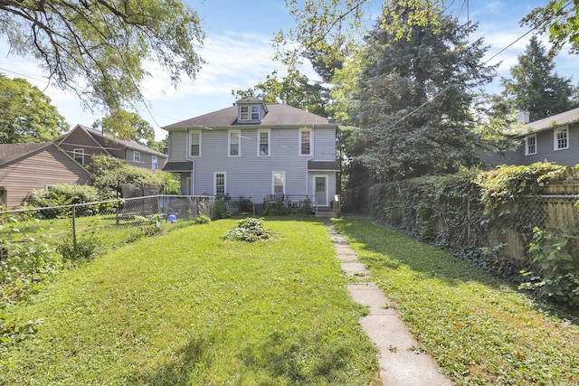 rear view of house featuring a lawn