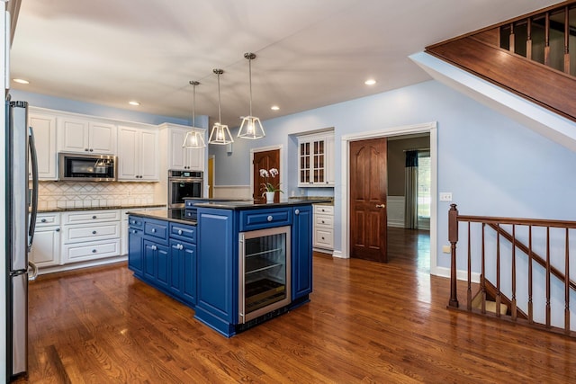 kitchen featuring blue cabinetry, wine cooler, white cabinetry, and appliances with stainless steel finishes