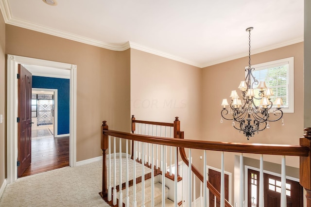 hallway with a chandelier, hardwood / wood-style floors, and ornamental molding