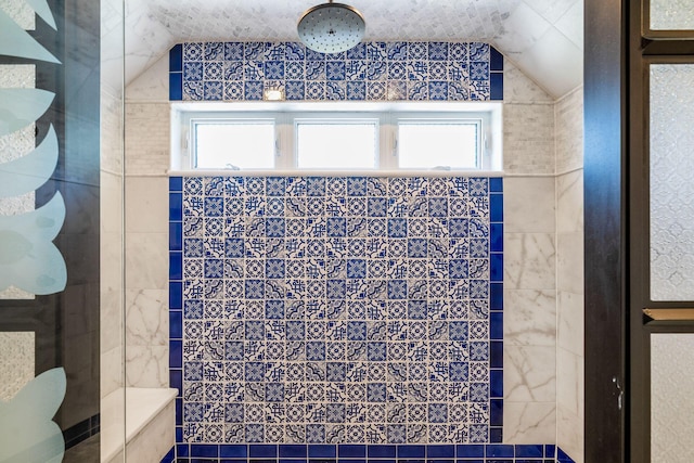 bathroom featuring a tile shower, tile walls, and lofted ceiling