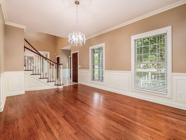 interior space featuring hardwood / wood-style flooring, a notable chandelier, and ornamental molding