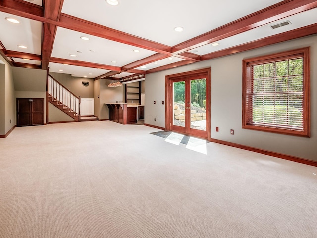 unfurnished living room featuring light carpet, beam ceiling, a wealth of natural light, and coffered ceiling