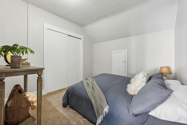 bedroom featuring light colored carpet and vaulted ceiling