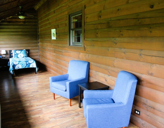 living area featuring hardwood / wood-style flooring and rustic walls