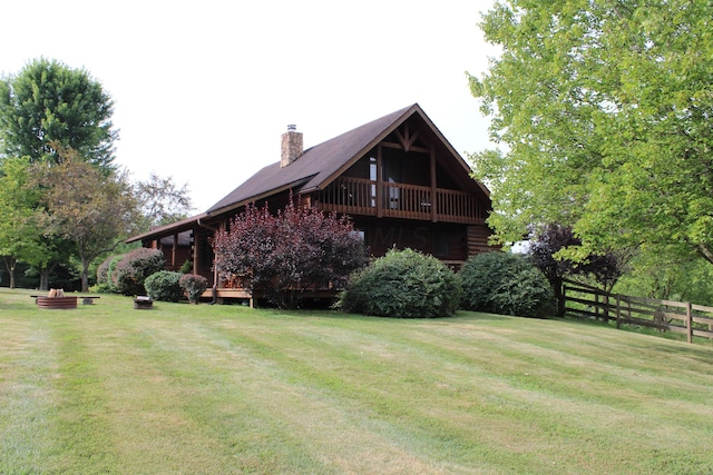 exterior space featuring a wooden deck and a lawn