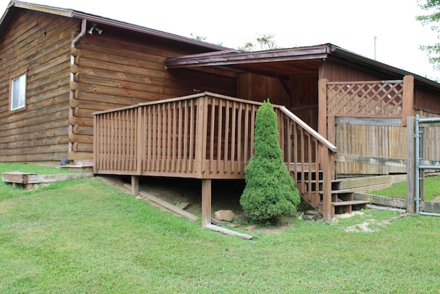 rear view of property featuring a wooden deck and a yard