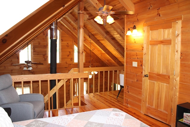 interior space with ceiling fan, vaulted ceiling with beams, wooden walls, wood-type flooring, and wooden ceiling