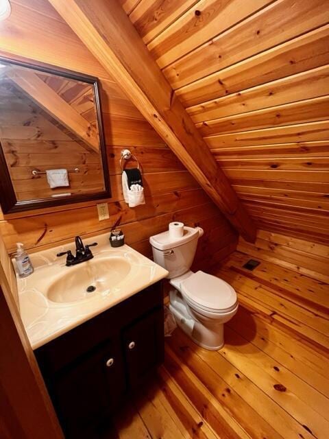 bathroom with wooden walls, vanity, wood-type flooring, wooden ceiling, and toilet