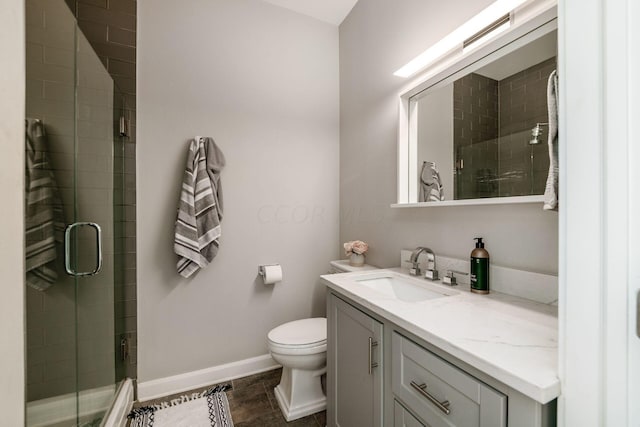 bathroom with tile patterned flooring, vanity, an enclosed shower, and toilet