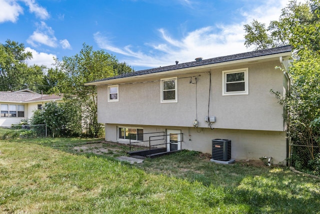 back of house with a lawn and central AC