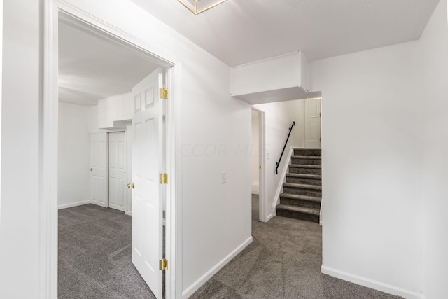 hall featuring dark colored carpet