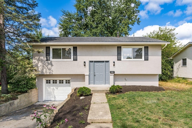 raised ranch featuring a front yard and a garage