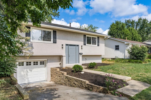 raised ranch with a front lawn and a garage