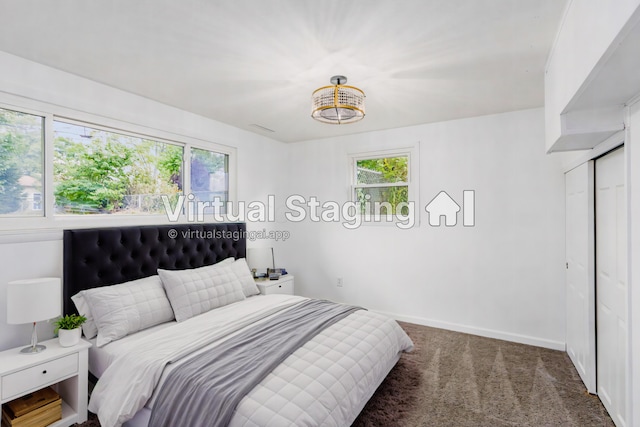 bedroom with dark carpet, a closet, and an inviting chandelier