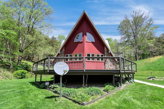 rear view of house featuring a wooden deck and a lawn