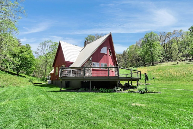 back of house featuring a wooden deck and a lawn