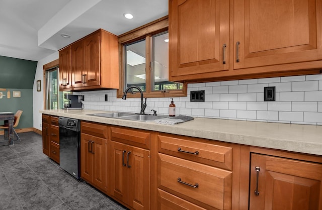 kitchen featuring dark tile patterned flooring, dishwasher, sink, and tasteful backsplash